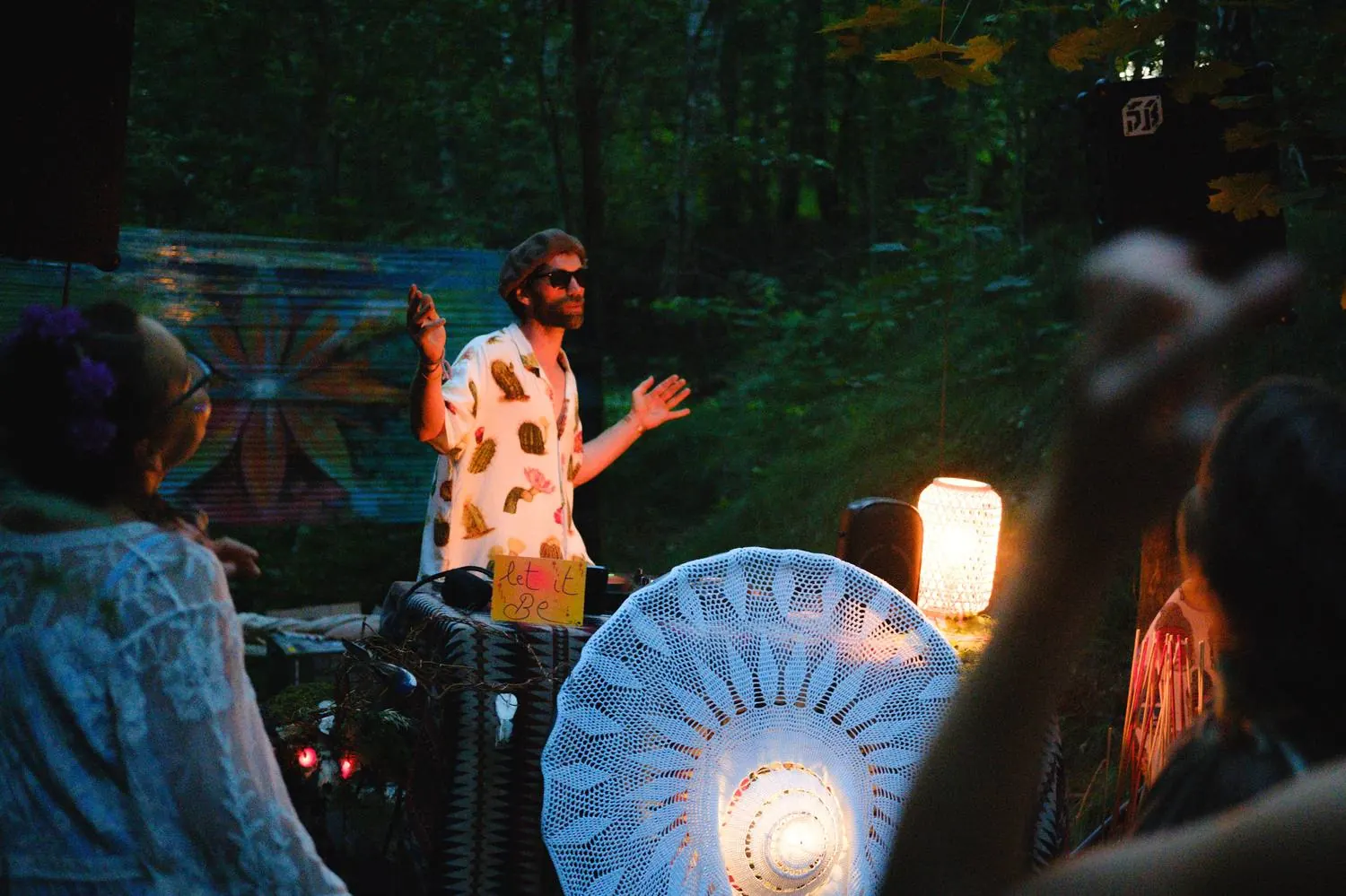Boris dancing behind the decks among lanterns in the forest