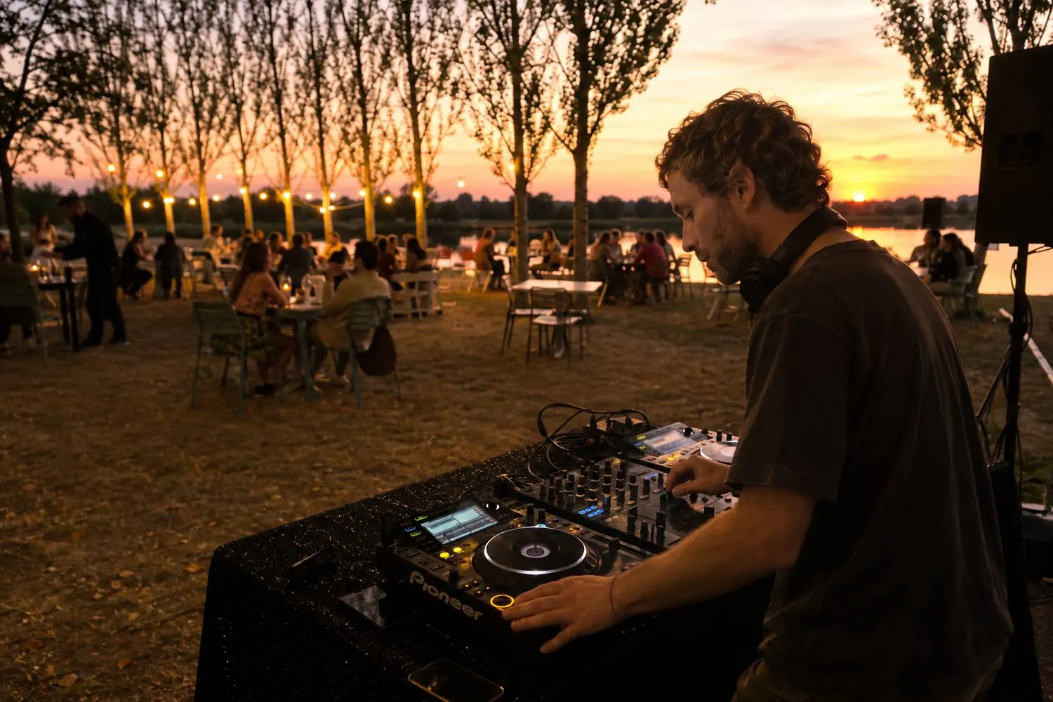 Boris at the decks at sunset, guests at long tables by the water