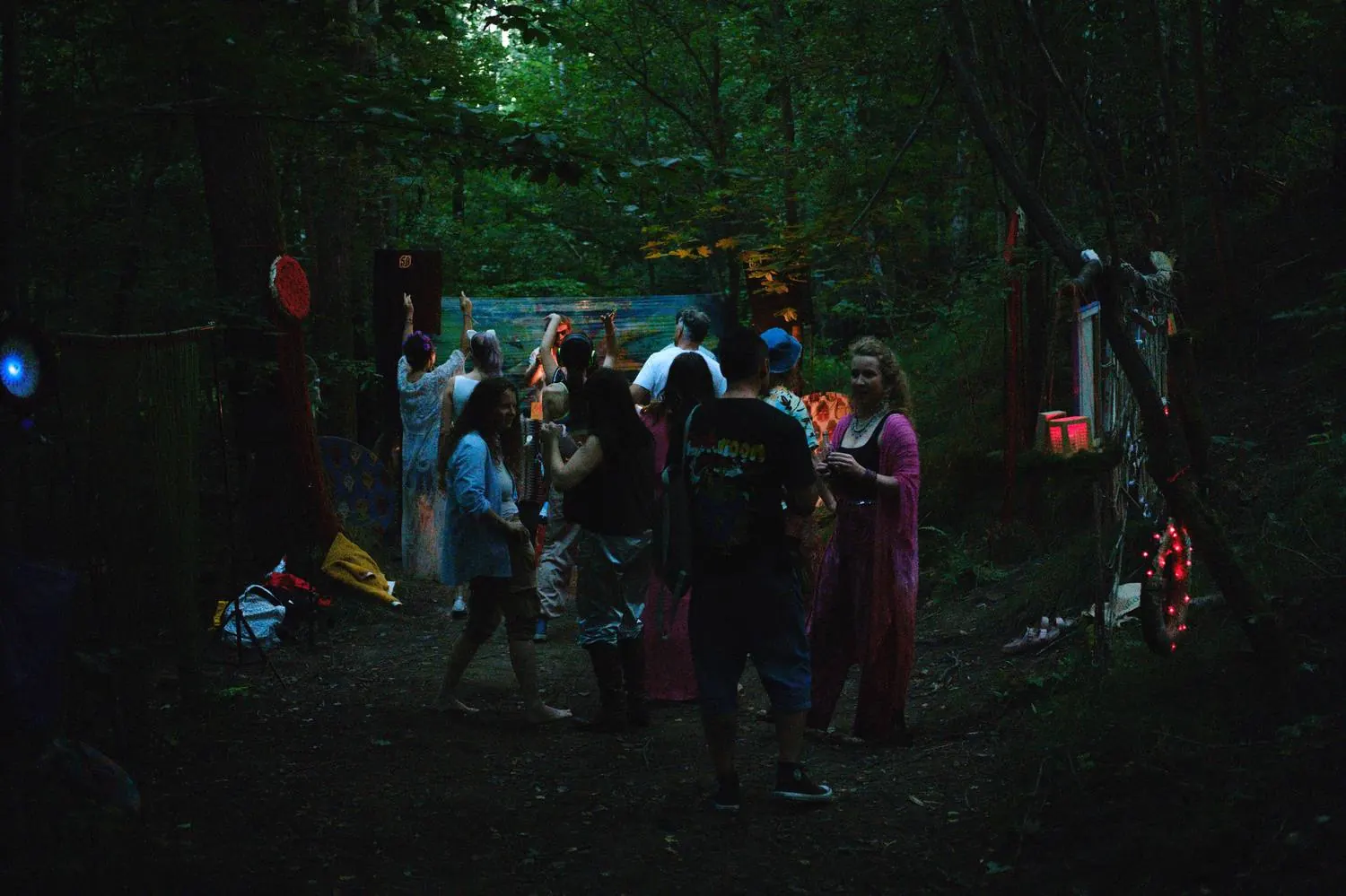 Guests gathering at dusk in a forest clearing